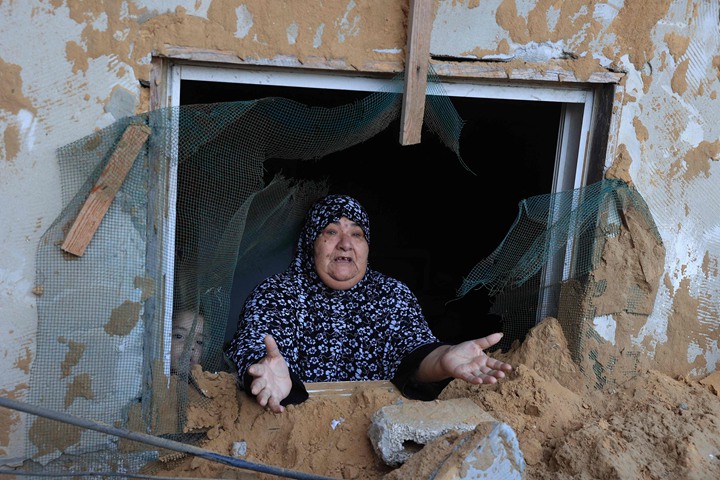 10月15日,以色列的导弹击中加沙南部拉法市(Rafah)一个难民营,侥幸逃过一劫的巴勒斯坦妇女一脸无奈。尽管巴勒斯坦人从加沙北部逃到南部,但南部地区也未必安全。(法新社)