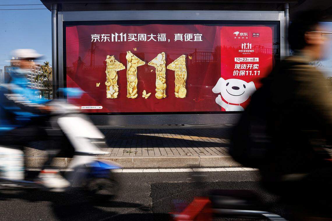 京东在今年双十一活动中取得不俗成绩。近30个品牌上星期一(10月23日)开售首周的销售额就突破10亿元人民币。图为北京市民10月26日骑车路过宣传双十一活动的京东广告版。(路透社)