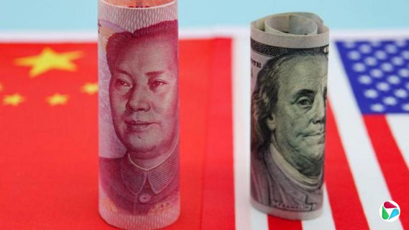 中国和美国的钞票卷起来,竖立在两国国旗上。