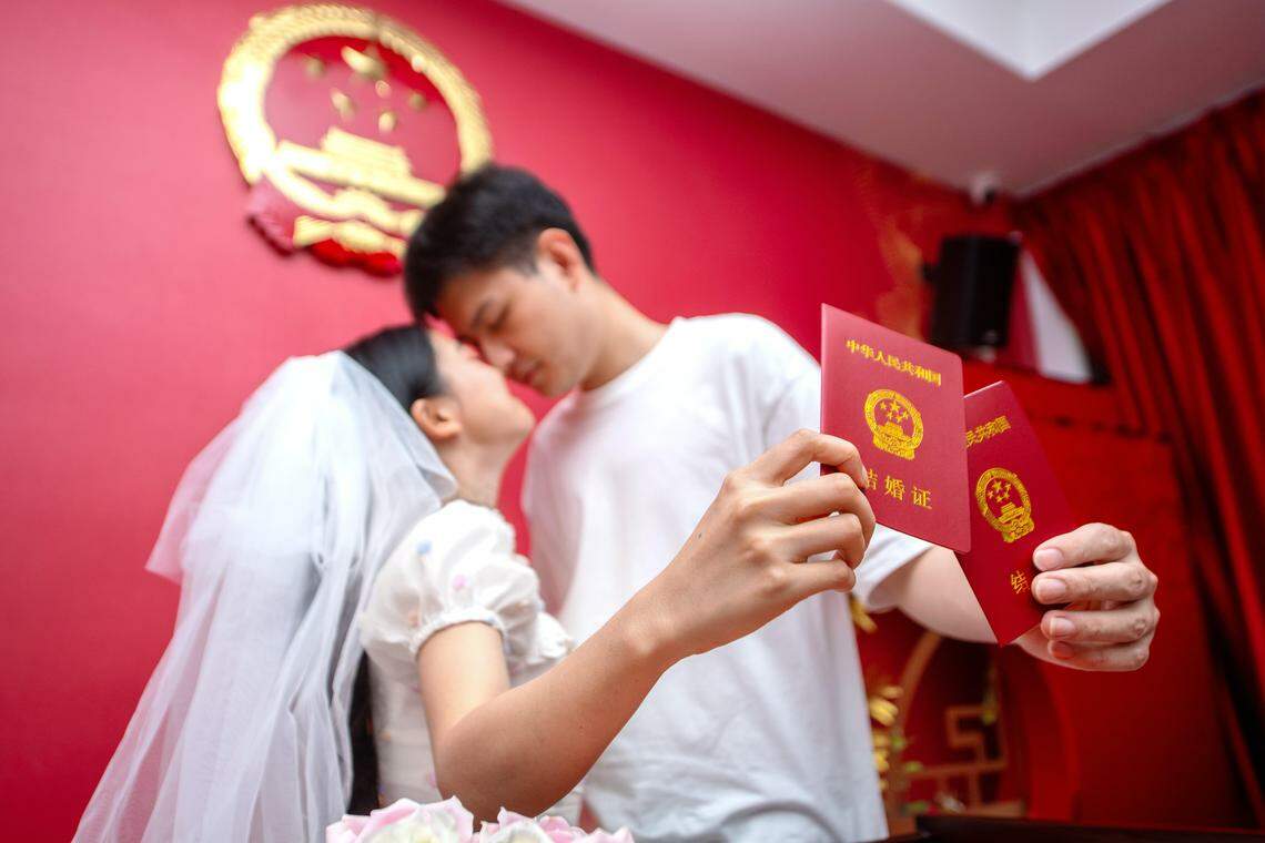 中国去年结婚登记人数跌破700万对,触及历史最低点。图为一对新人今年七夕(8月22日)在浙江省湖州市长兴县民政局婚姻登记处领取结婚证。(新华社)