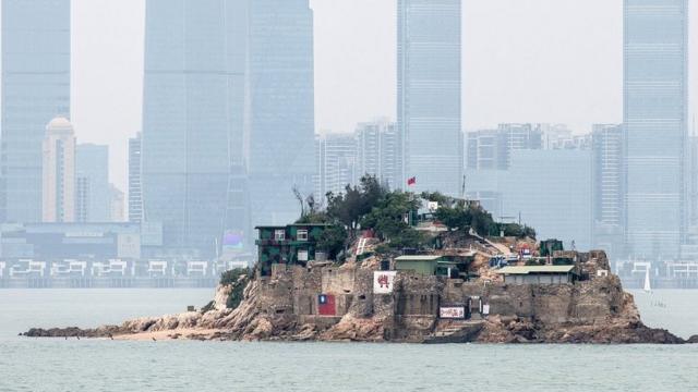 台湾金门离岛小岛——狮屿。岛上插有中华民国国旗,对面高楼大厦是福建厦门市(2018年4月20日资料照片)。