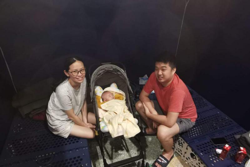 来自印尼的东华大学助理教授张汉利一家三口,包括两个月大的女儿,在安心关怀站的帐篷隔间里避难。(温伟中摄)