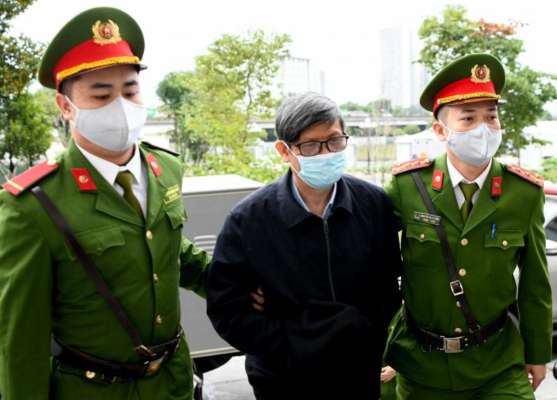 越南反腐败运动已持续十余年,数名高官落马。今年1月3日,越南前卫生部长阮青龙(中)因冠病检测试剂盒受贿案在河内受审,被判处18年监禁。(法新社)