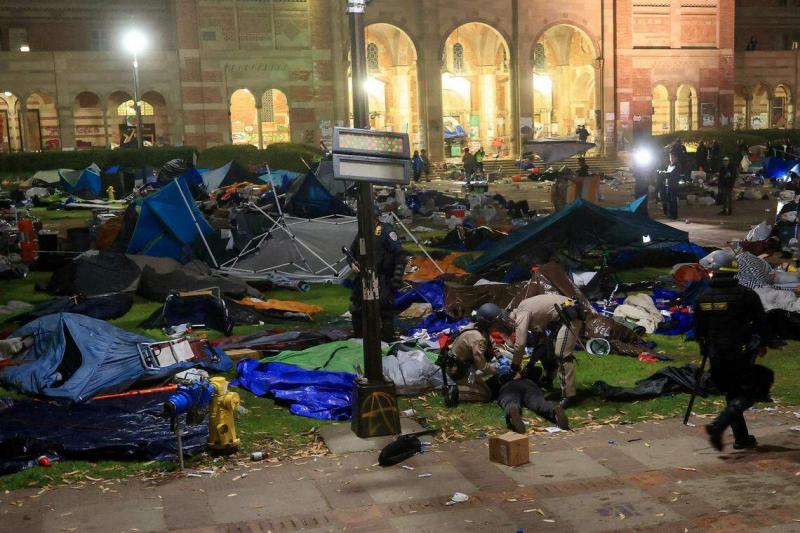 执法人员星期四在加州大学洛杉矶分校强行拆除反以哈战争示威者在校内广场搭建的营地,同时逮捕示威者。(路透社)