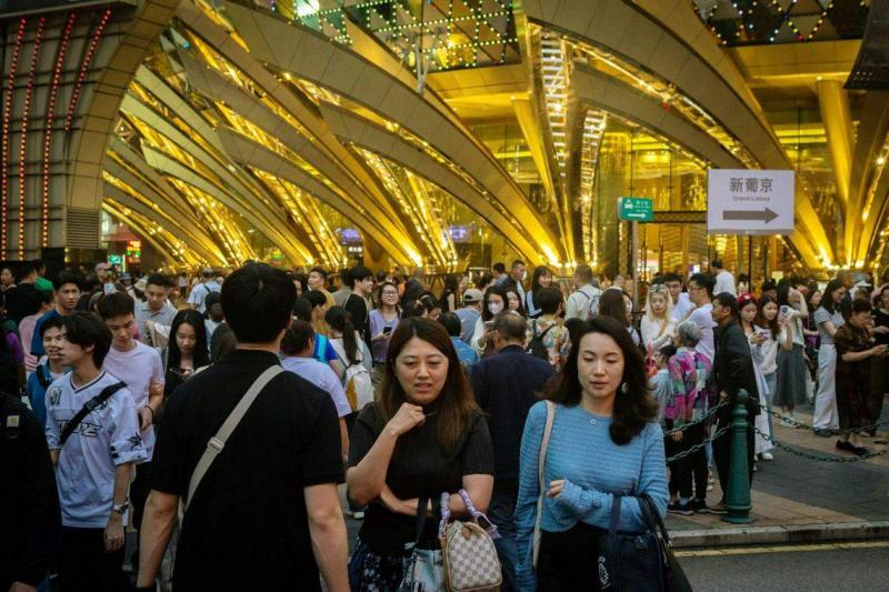 中国五一黄金周入境澳门的旅客量理想,继续为香港股市的博彩股带来支持。图为5月2日澳门新葡京赌场外人流如潮。(彭博社)