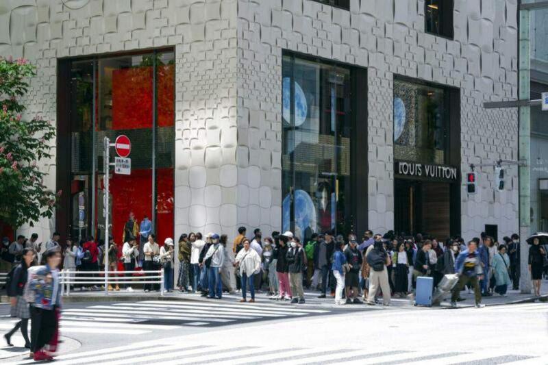 许多消费者5月2日在日本东京银座的路易威登店外排队,准备进入店内购物。(彭博社)